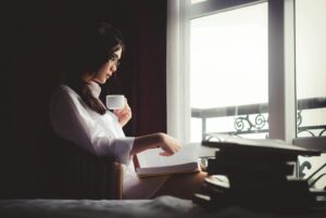 Woman sitting with a notebook and cup of coffee