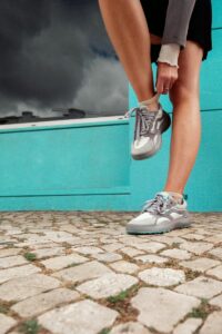 A person is putting on their athletic sneakers.