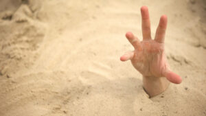 hand reaching out of quick sand