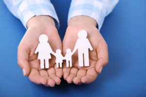 Hand holding paper cut out of family