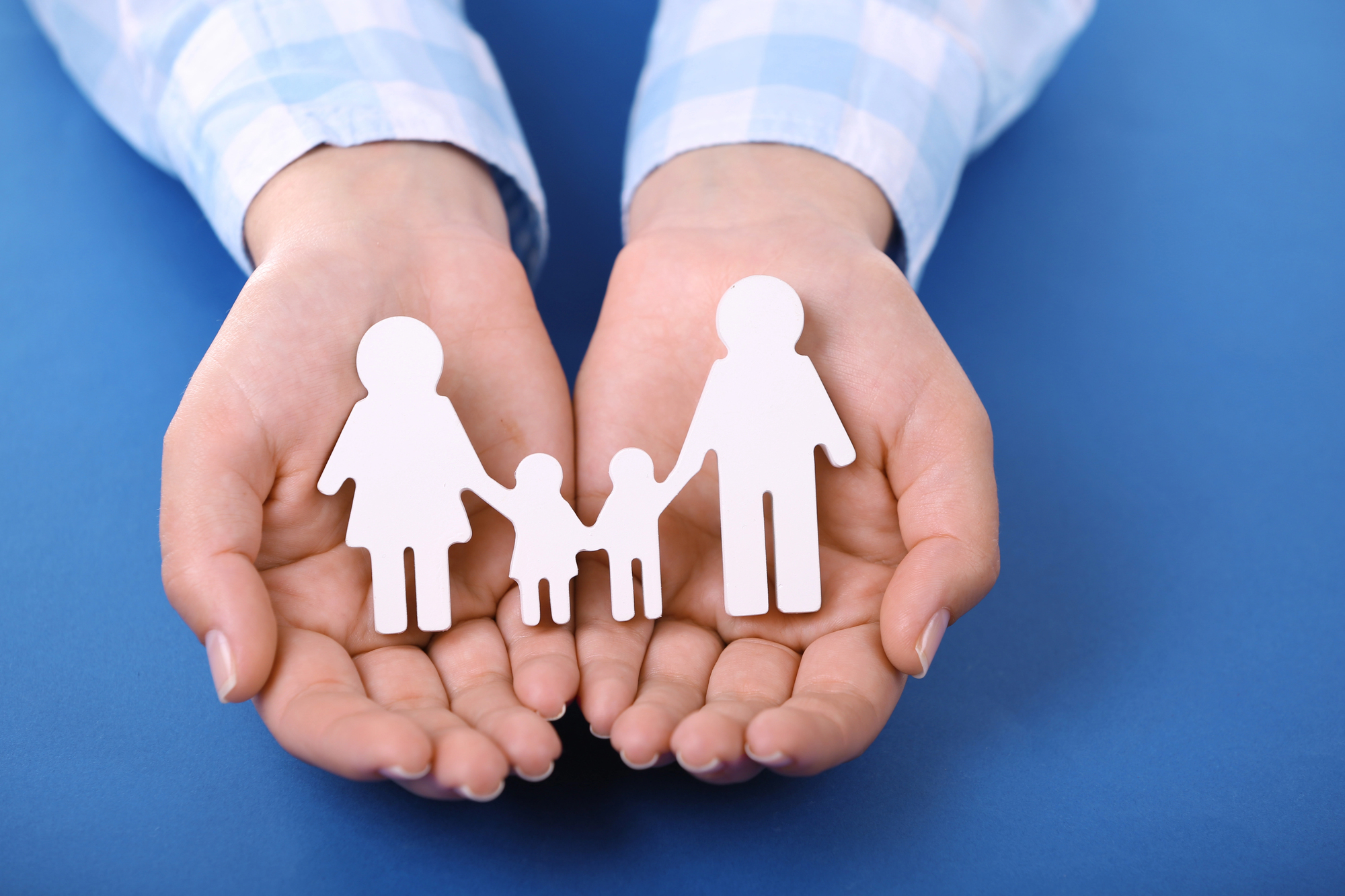 Hand holding paper cut out of family