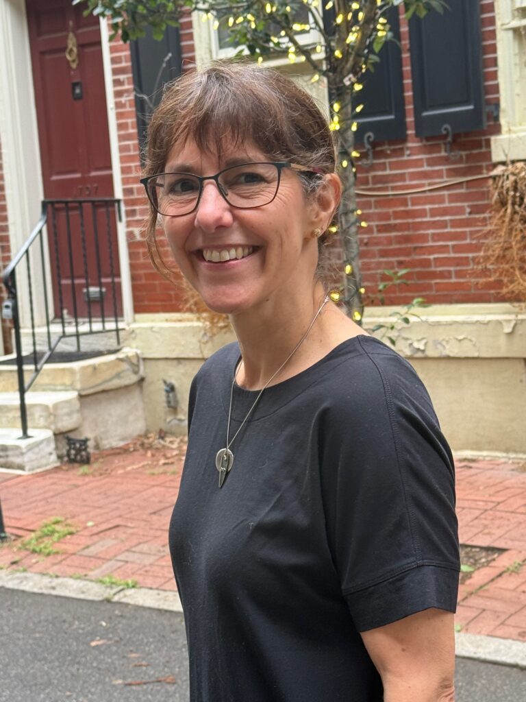 Author Michelle Barker standing in front of a red brick building.